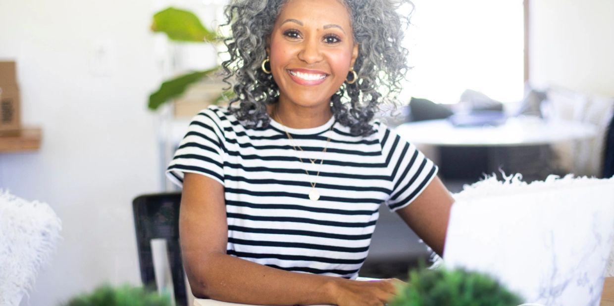 woman smiling. She’s stepping into the next chapter with boldness and grace.