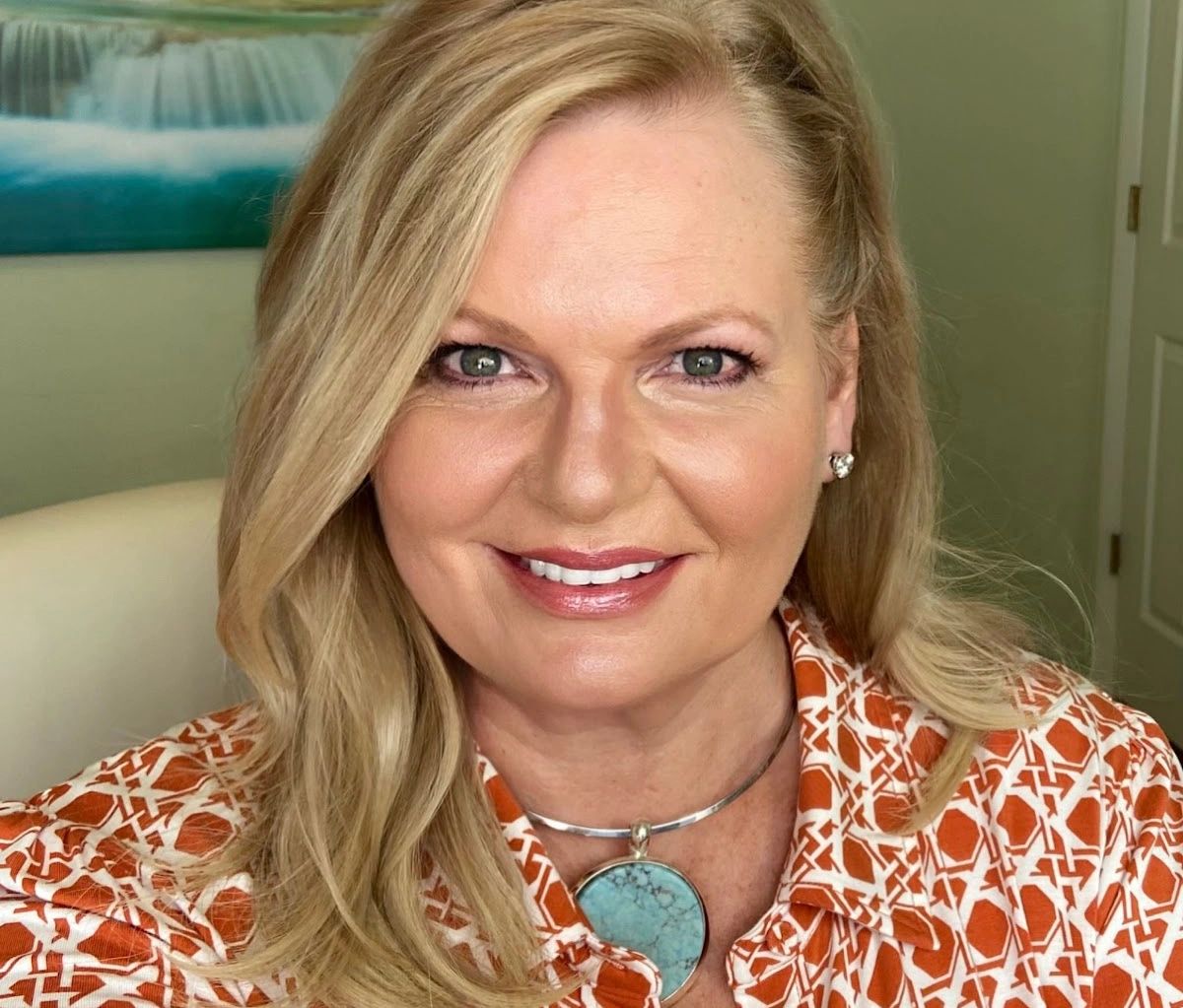 Coach Deb Stewart smiling confidently, styled —representing purpose, power, and femininity.