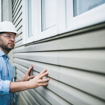 Arctic Roofing expert performing a siding inspection, ensuring quality repairs and install