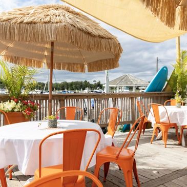 A table with orange chairs and tiki umbrella  on the outside deck LI's The Tiki @ Sunset Harbour, 