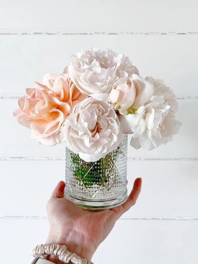 Candle jar being reused to hold flowers