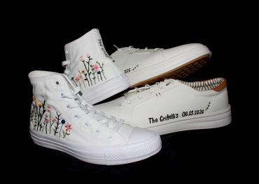 White sneakers with floral designs and personalized text.
