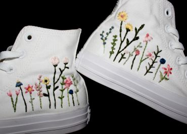 White sneakers with colorful floral embroidery.