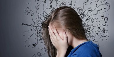 A girl overwhelmed with chaotic thoughts covering her face.