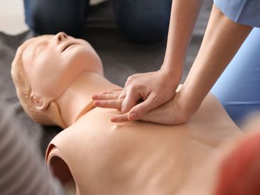 Resuscitation dummy with person doing CPR 