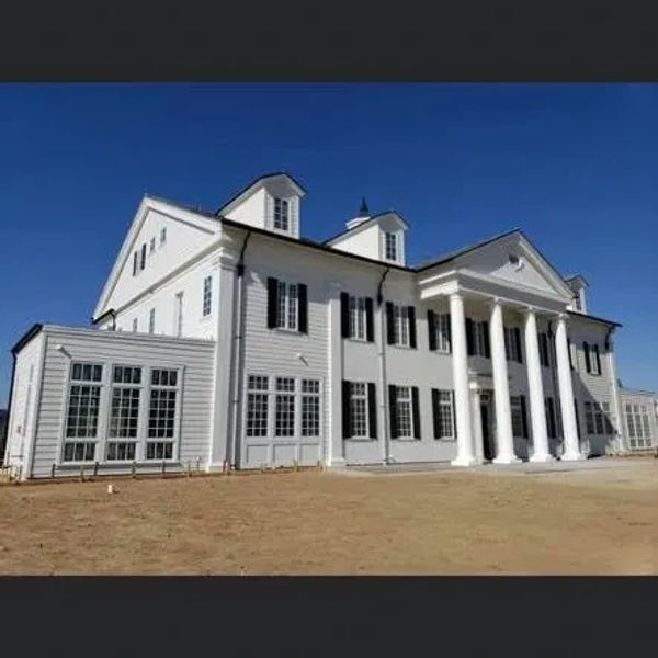 Large white colonial-style house with tall pillars.