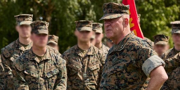 Military leader addressing troops outdoors.
