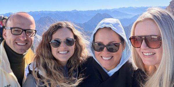 Group of four friends smiling on a mountain hike.