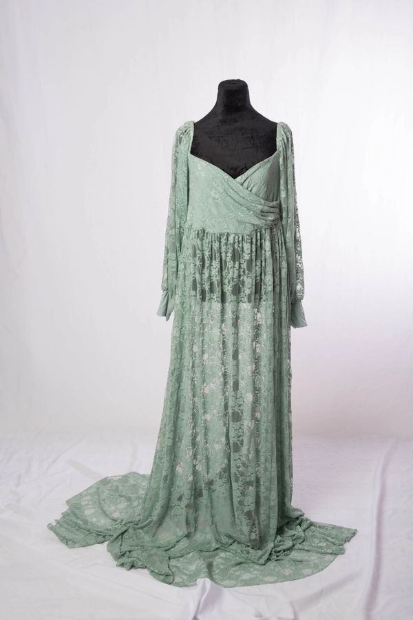 Elegant mint green lace gown with long sleeves and a flowing train.