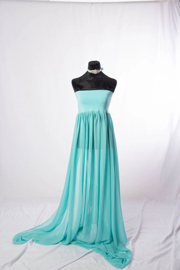 Elegant turquoise strapless gown with flowing sheer skirt on mannequin.