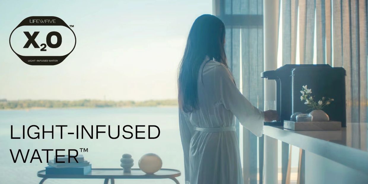 Woman in robe making light-infused water with LifeWave X2O device.