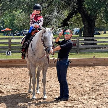Kid riding horse with training holding reins
