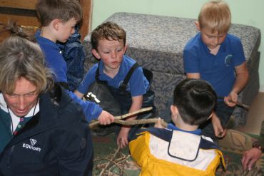Children playing with sticks indoors.
