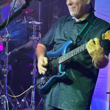 Musician playing electric guitar during a live performance.