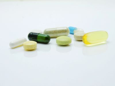 Various pills of various colors with a white background.