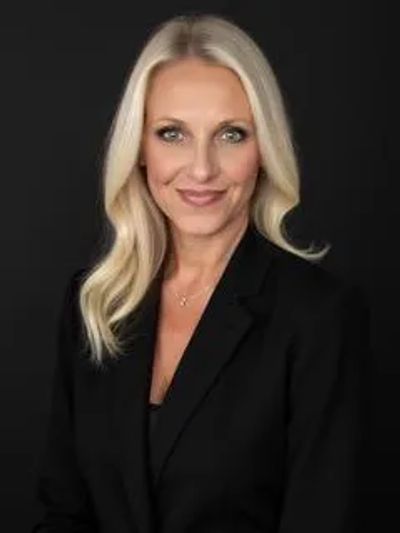 Professional portrait of a confident woman in black blazer.