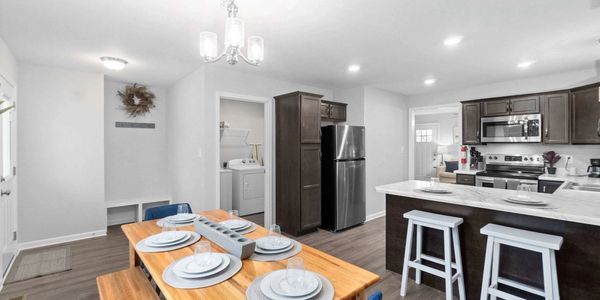 Modern kitchen and dining area with stainless steel appliances.