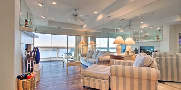 Modern living room with ocean view and striped furniture.