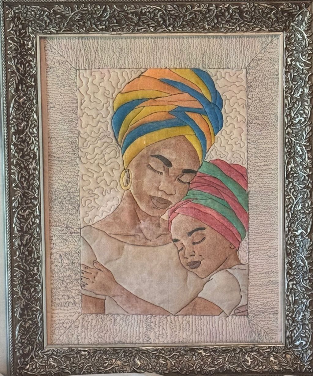 Artwork of a mother and child embracing, both wearing colorful headwraps.
