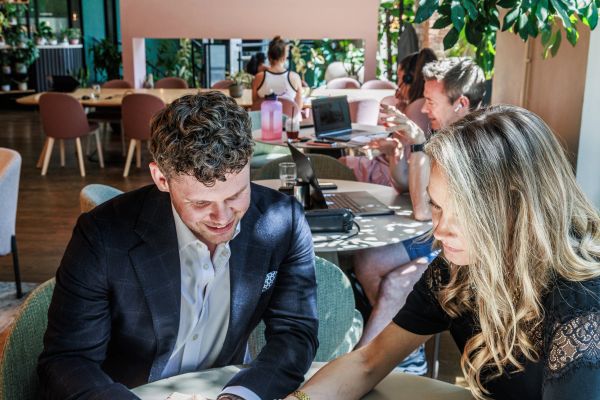 A man and a woman working together in a bright, modern cafe.