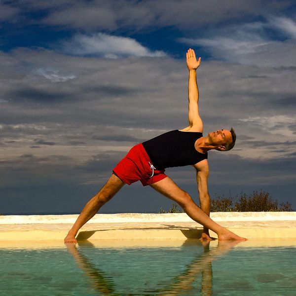 Robert Ashman practicing Trikonasana by the pool