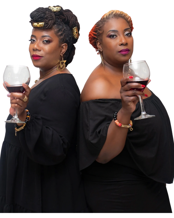 two black women holding a wine glass