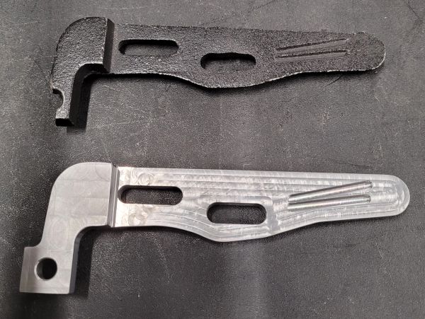 Two machined metal parts, one rough and one polished.