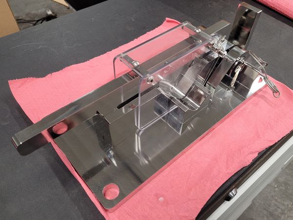 Stainless steel and clear acrylic device on a pink cloth.