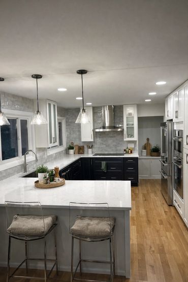 Modern kitchen with white and black cabinetry and pendant lighting.