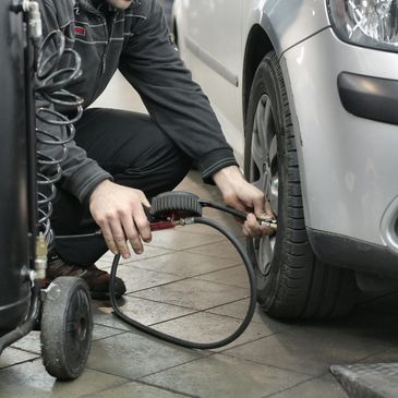 A mechanic filling a tire with air