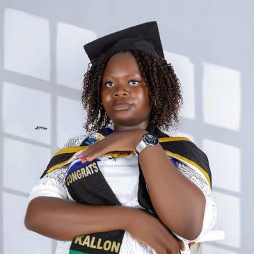 Young woman in graduation attire posing confidently with a diploma.