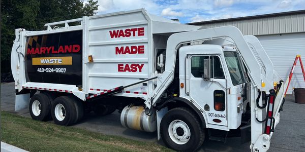 Maryland Waste garbage truck parked outside a building.