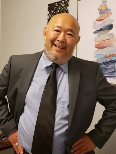 Smiling man in a suit posing confidently indoors.