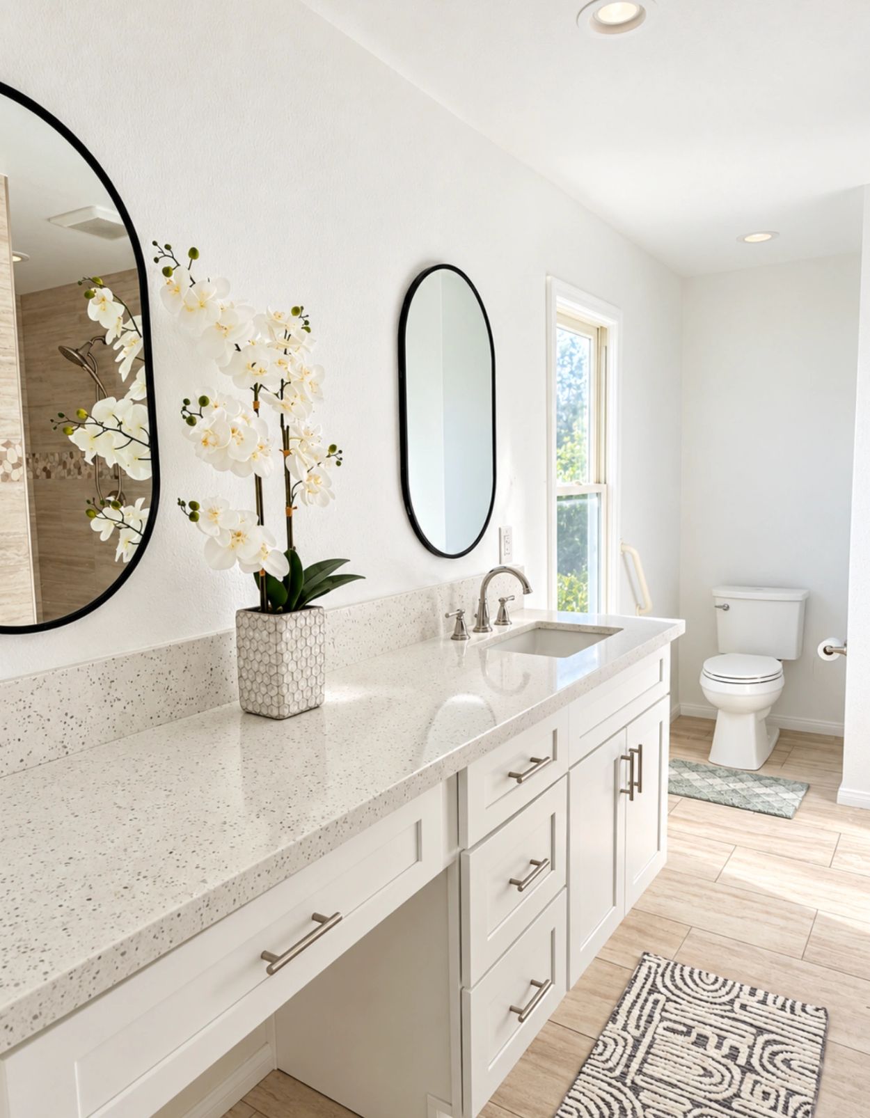 Bright bathroom with double mirrors and white orchid.