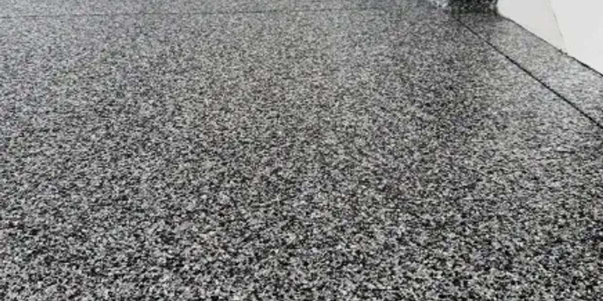 Speckled epoxy garage floor with matching wall base. Full Flake