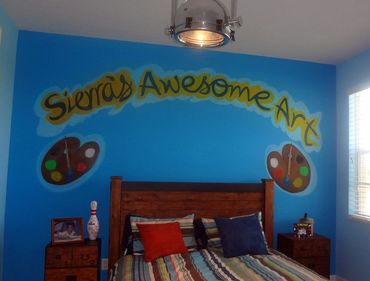Bedroom wall with colorful art and text.