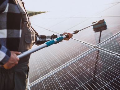 Man worker in the firld by the solar panels
