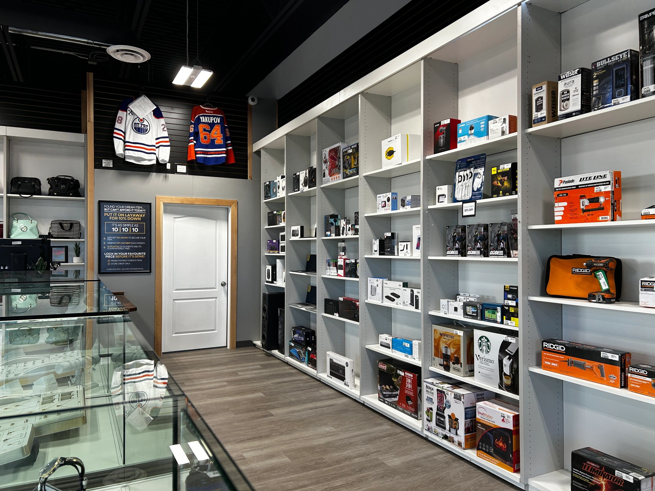 Retail store aisle displaying electronics, tools, and accessories on shelves.