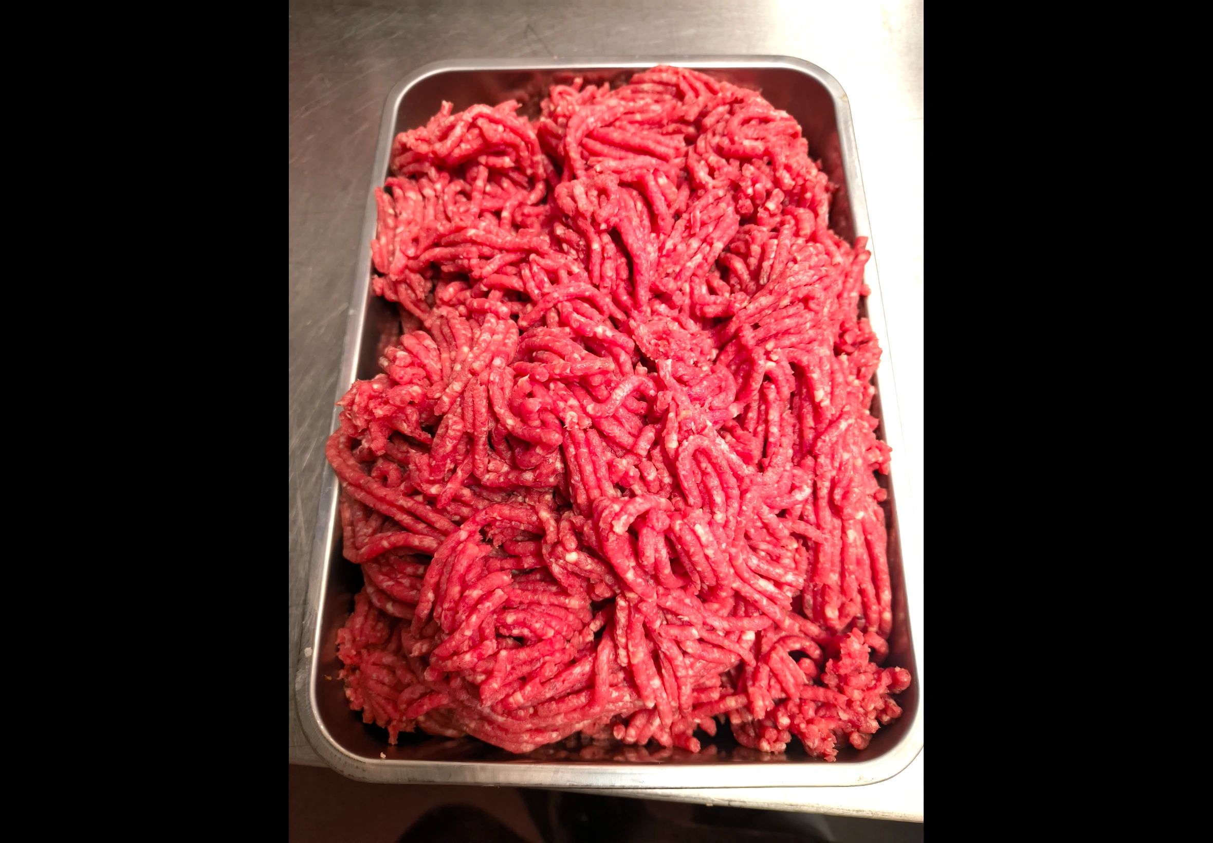 Fresh ground beef in a metal tray.