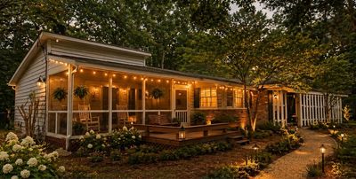 Cozy house at dusk with warm porch lights and lush greenery.