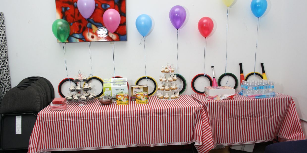 Table set up with cupcakes, food, balloons, juggling equipment at a kids circus birthday party