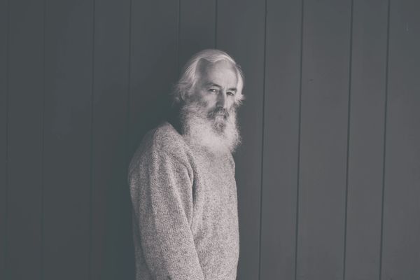 Man standing against wall for book photo photographed by Reichert Photography