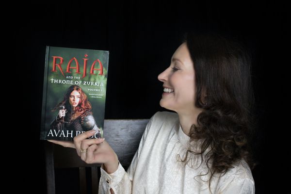 Woman holding up her published book photographed by Reichert Photography