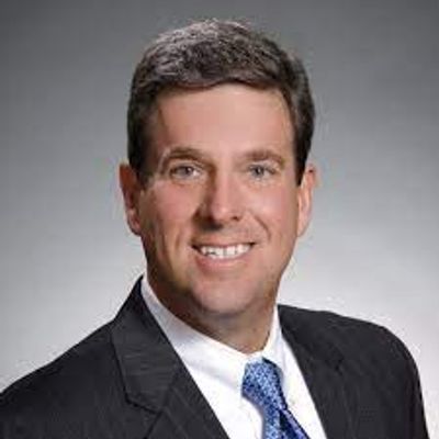 Professional headshot of a man in a suit and tie.