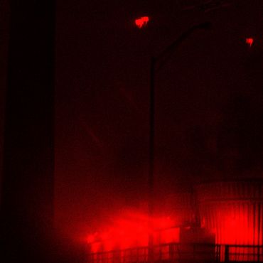 Red glowing lights illuminating a dark urban area.
