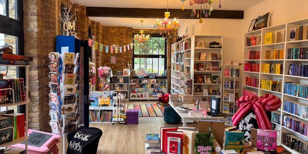 Cozy bookstore with colorful books, cards, and decorations.