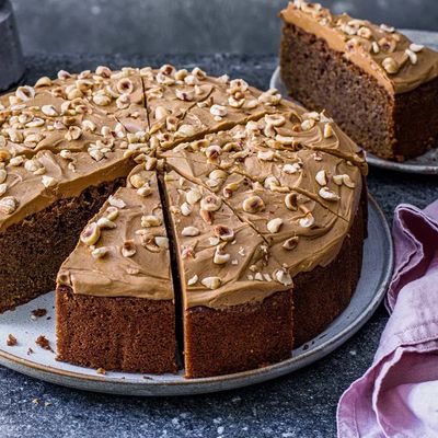 Chocolate cake with frosting and chopped nuts on top.