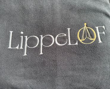 Logo embroidery on a fabric, reads LippeLOF with a symbol.