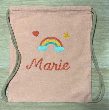 Pink drawstring bag with rainbow and name Marie.