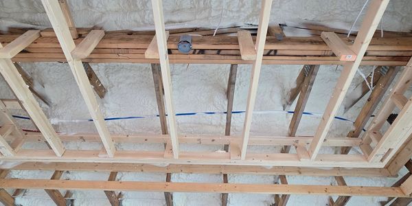 Ceiling insulation and wooden framing in a building under construction.